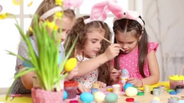 Mutlu çocuk yumurta Paskalya gününde boyama tavşan kulakları giyiyor.