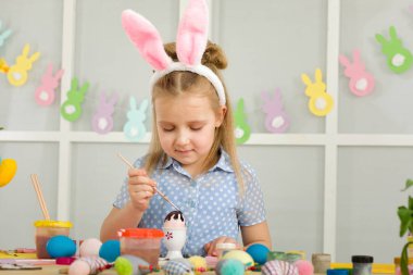 Paskalya yumurtaları evde boyama Paskalya tavşan kulaklı kız küçük çocuk.