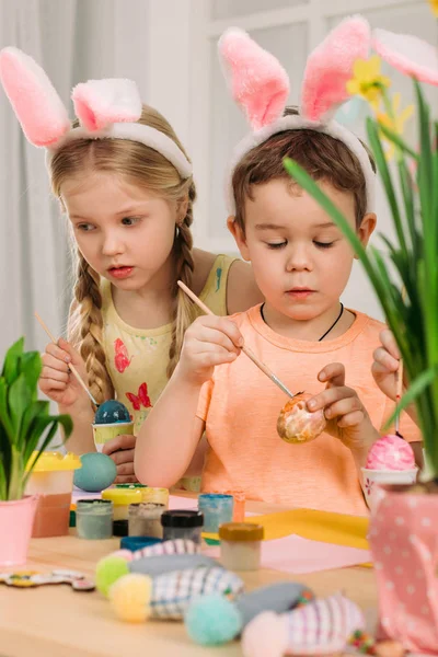 Carino bambini pittura uova di Pasqua a casa . — Foto Stock