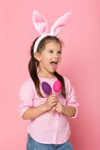 Ładna dziewczynka z Easter bunny uszy gospodarstwa kolorowych jaj — Zdjęcie stockowe