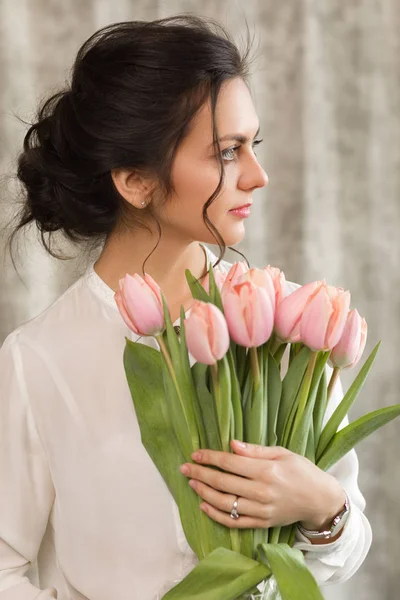 チューリップの花の花束と美しいブルネットの女性 — ストック写真