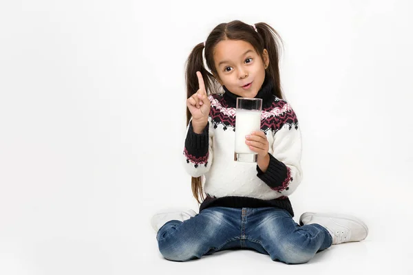 Niña sosteniendo un vaso de leche sobre fondo blanco — Foto de Stock