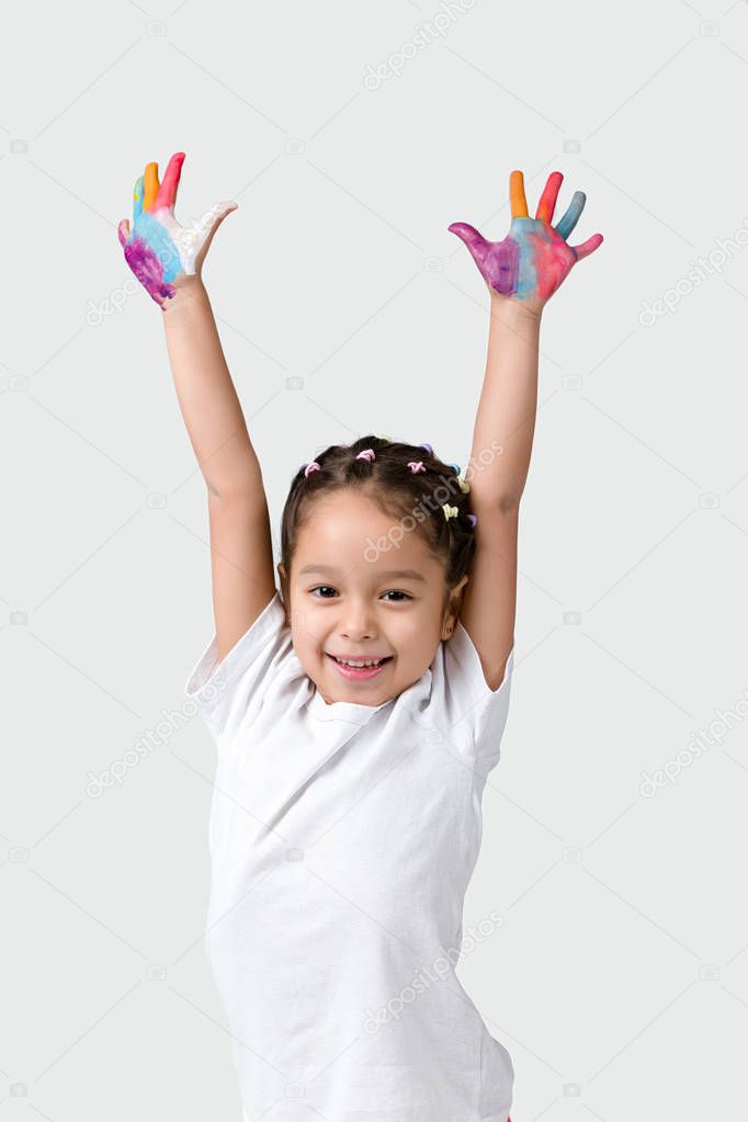 little child girl with hands painted in colorful paint