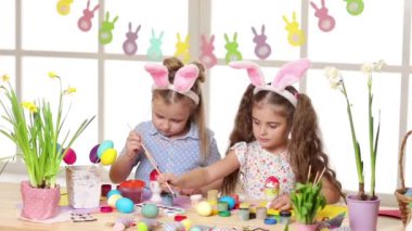 Mutlu çocuk yumurta Paskalya gününde boyama tavşan kulakları giyiyor.