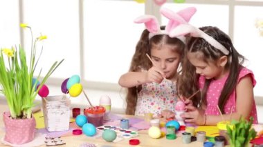Mutlu çocuk yumurta Paskalya gününde boyama tavşan kulakları giyiyor.