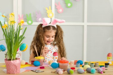 Paskalya yumurtaları evde boyama Paskalya tavşan kulaklı kız küçük çocuk.