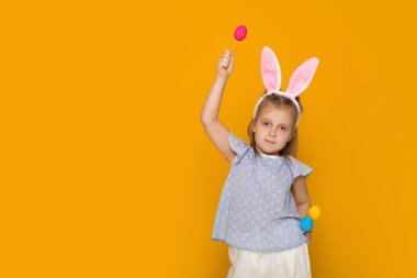 Paskalya tavşan kulakları renkli yumurta holding ile sevimli küçük kız