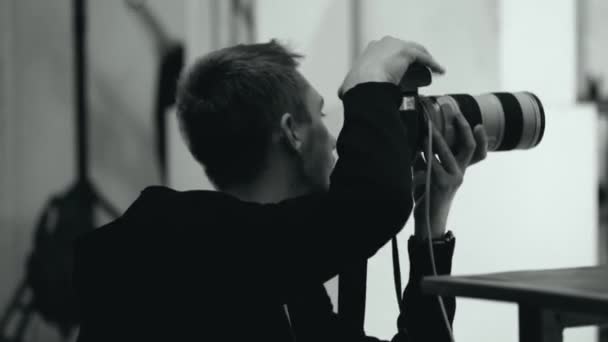 Фотограф берет цифровую камеру в фотостудии — стоковое видео