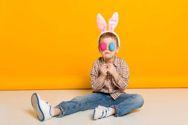 küçük çocuk çocuk tutan renkli yumurta Paskalya bunny kulaklar ile