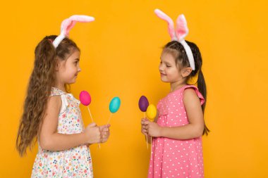 renkli yumurta tutan Paskalya tavşan kulaklı küçük kızlar
