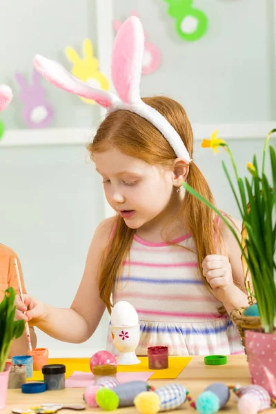 Bambina bambina con le orecchie di coniglio di Pasqua pittura uova di Pasqua — Foto Stock