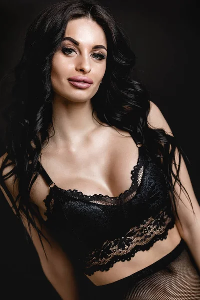 Mujer sexy en encaje negro sensual lencería y pantimedias con pelo largo rizado —  Fotos de Stock