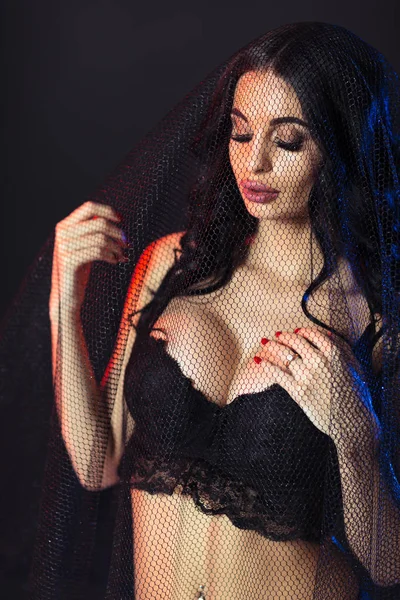 Portret van een mooie sexy brunette vrouw via lace — Stockfoto