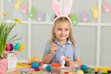 Paskalya yumurtaları evde boyama Paskalya tavşan kulaklı kız küçük çocuk.