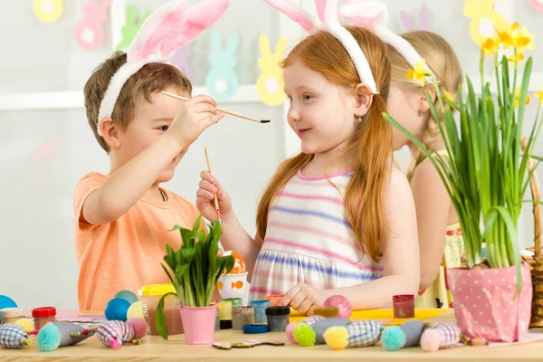 Carino bambini pittura uova di Pasqua a casa . — Foto Stock