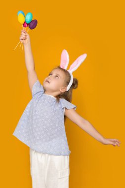 Paskalya tavşan kulakları renkli yumurta holding ile sevimli küçük kız