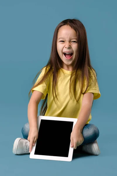 Petite fille tenant une tablette vierge — Photo