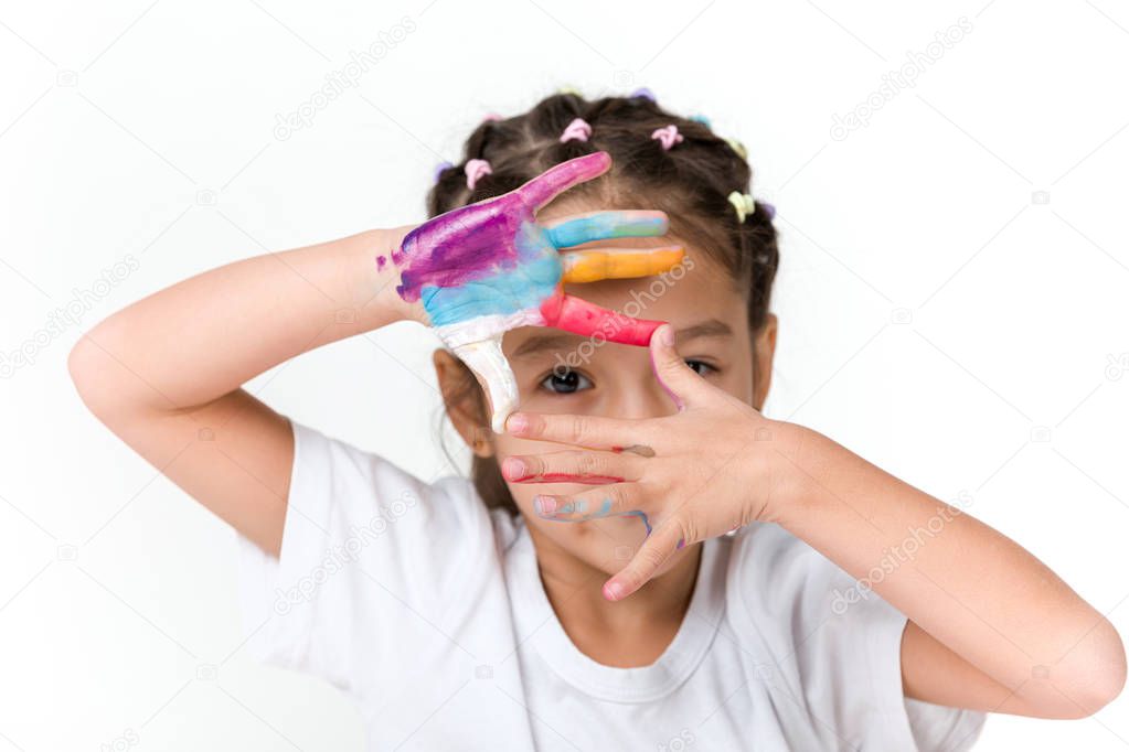 little child girl with hands painted in colorful paint