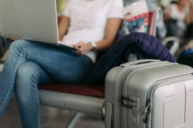 havaalanında dizüstü bilgisayar kullanarak kadın yolcu