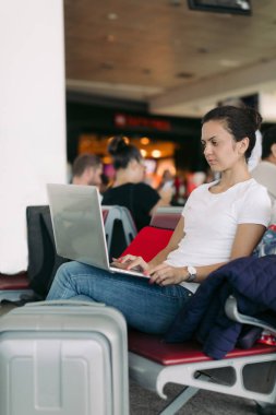 havaalanında dizüstü bilgisayar kullanarak kadın yolcu