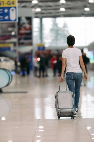 Junge Frau läuft mit Koffer in Flughafen — Stockfoto