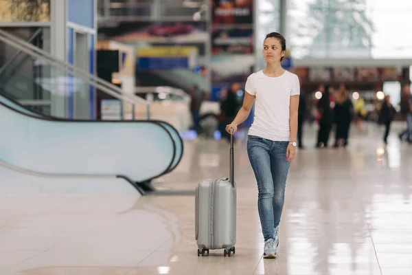 Junge Frau läuft mit Koffer in Flughafen — Stockfoto