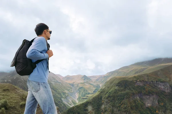 Tourist man with a backpack against the Caucasus Mountains — Stock Photo, Image