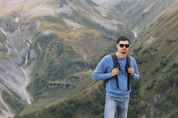 Uomo turistico con uno zaino contro le montagne del Caucaso — Foto Stock