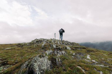 kadın bir yamaç üzerinde dürbün tırmanıyor