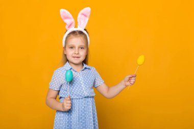 Paskalya tavşan kulakları renkli yumurta holding ile sevimli küçük kız