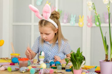 Paskalya yumurtaları evde boyama Paskalya tavşan kulaklı kız küçük çocuk.