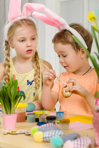 милые дети рисуют пасхальные яйца дома
.