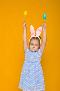 Paskalya tavşan kulakları renkli yumurta holding ile sevimli küçük kız