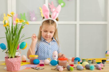 Paskalya yumurtaları evde boyama Paskalya tavşan kulaklı kız küçük çocuk.