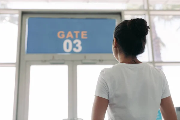 Frau steht vor Gate in Flughafen — Stockfoto