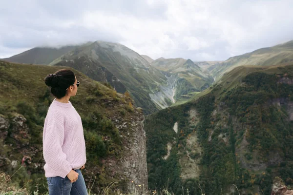 Junges Mädchen im Pullover blickt auf die kaukasischen Berge — Stockfoto