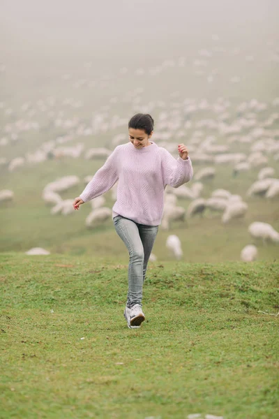 Dağlarda koyun sürüleri karşı mutlu genç kadın — Stok fotoğraf
