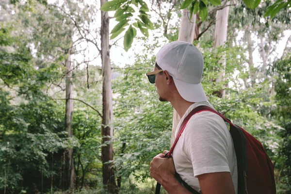 숲 속을 걷고 있는 가방을 든 남자 — 스톡 사진