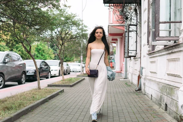 Привлекательная женщина в одежде гуляет по улицам города — стоковое фото