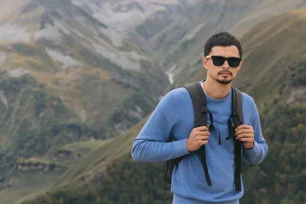Uomo turistico con uno zaino contro le montagne del Caucaso — Foto Stock