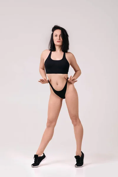 Jovem mulher em forma posando no fundo branco — Fotografia de Stock