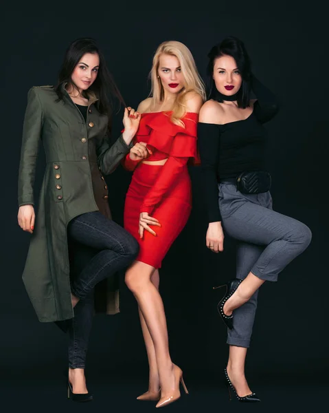 Young women friends standing over black background — Stock Photo, Image