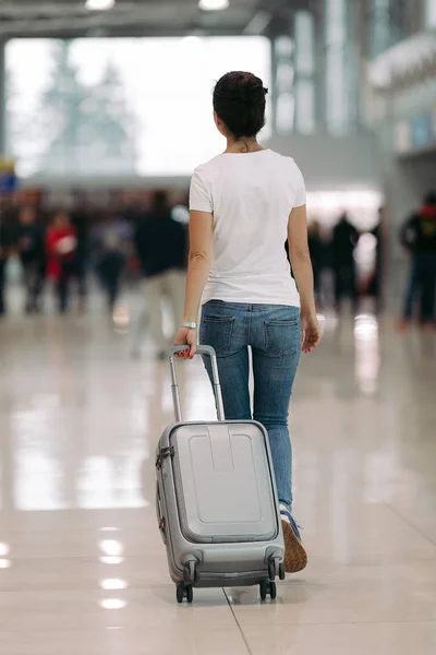 Junge Frau läuft mit Koffer in Flughafen — Stockfoto