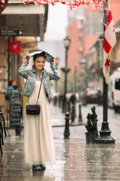 Mujer con mapa camina por la ciudad vieja en el día lluvioso — Foto de Stock