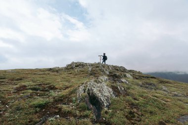 bir yamaç üzerinde dürbün bakarak turist kadın