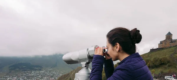 Turista mirando prismáticos en una ladera — Foto de Stock