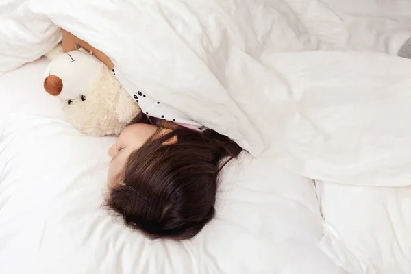 Menina bonito criança dormindo com ursinho de pelúcia — Fotografia de Stock