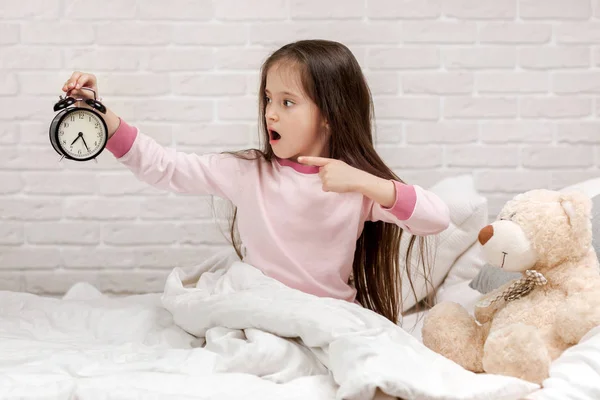 Bambina in pigiama con orologio — Foto Stock