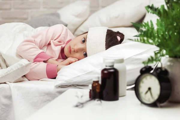 Menina criança doente deitada na cama com termômetro . — Fotografia de Stock
