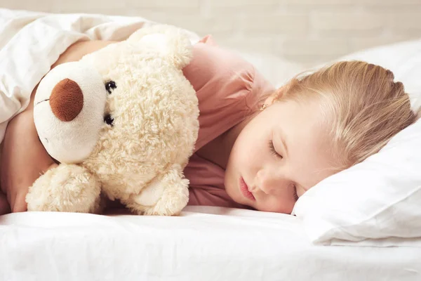 Menina bonito criança dormindo com ursinho de pelúcia — Fotografia de Stock